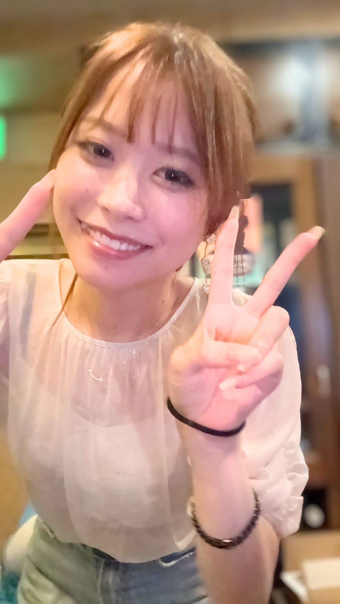 明るい笑顔でダブルピースをしている、プロダーツプレイヤー内堀遥香さんのアップ写真