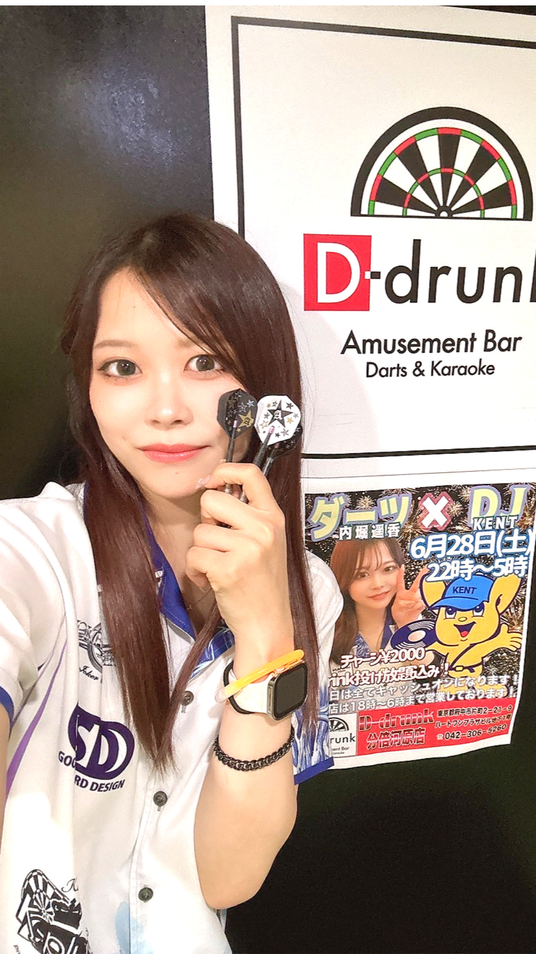 カウンターでドリンクを持って微笑む女性スタッフ