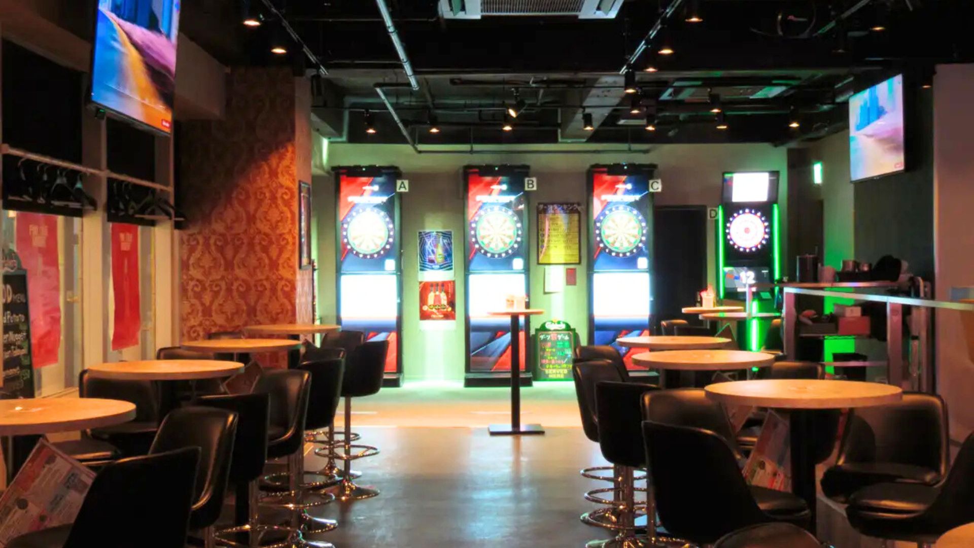 ダーツ&ビアポン BASE2 新宿歌舞伎町店の広々とした店内。左手にバーカウンターとオープンキッチン、フロアには多数のテーブル席が配置されている。